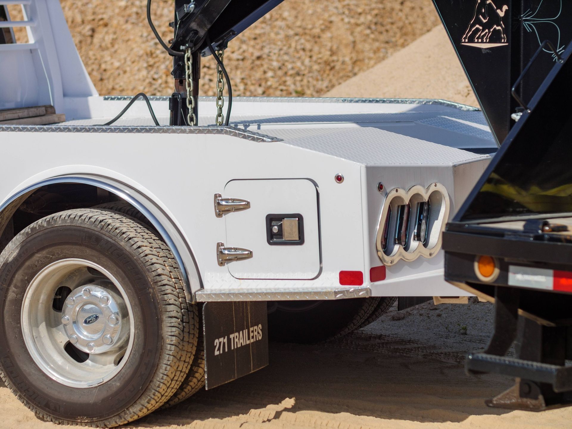 White truck bed with storage, chrome accents, and dual rear wheels.