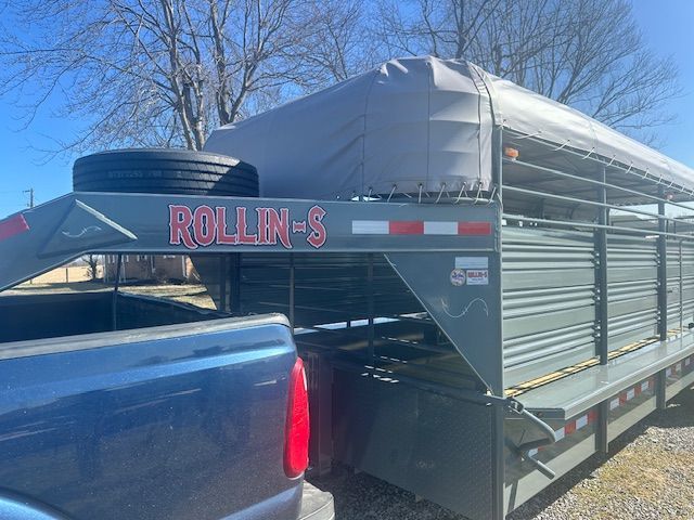 Blue truck hitched to a gray ROLLIN-S livestock trailer with a spare tire.