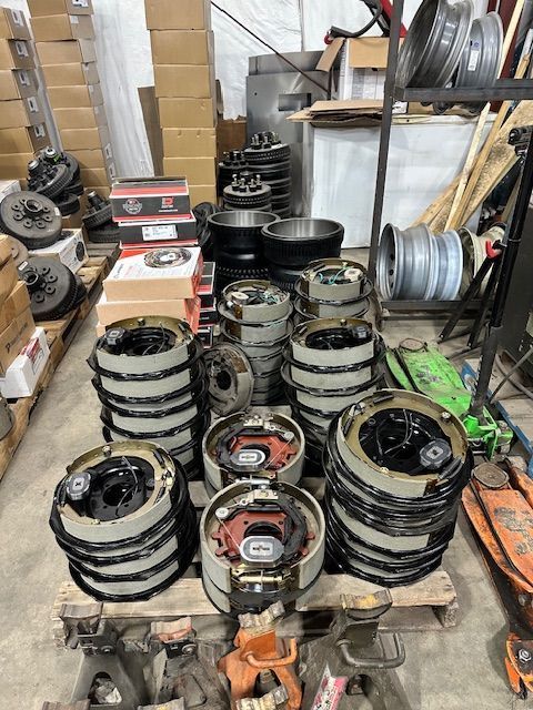 Stacks of brake assemblies and parts on pallets in a warehouse.