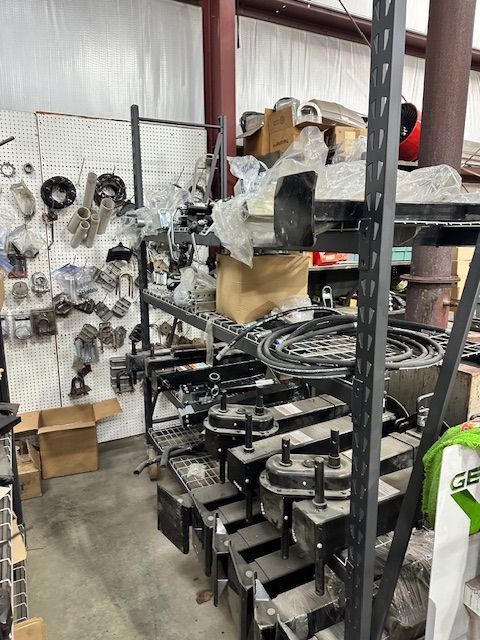 Shelves stocked with various metal vehicle parts in a storage area.