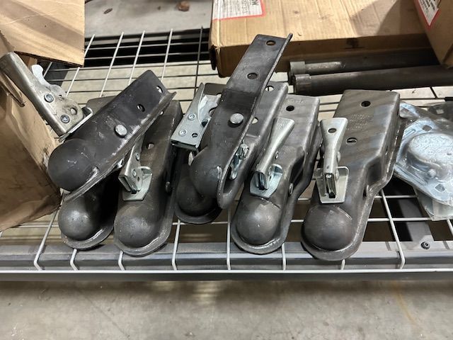 Metal trailer couplers in a storage shelf.