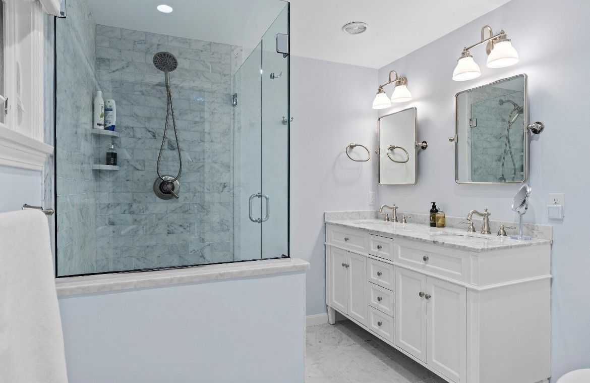 Kitchen remodel: light gray cabinets with gold hardware framing a pass-through to the dining area.