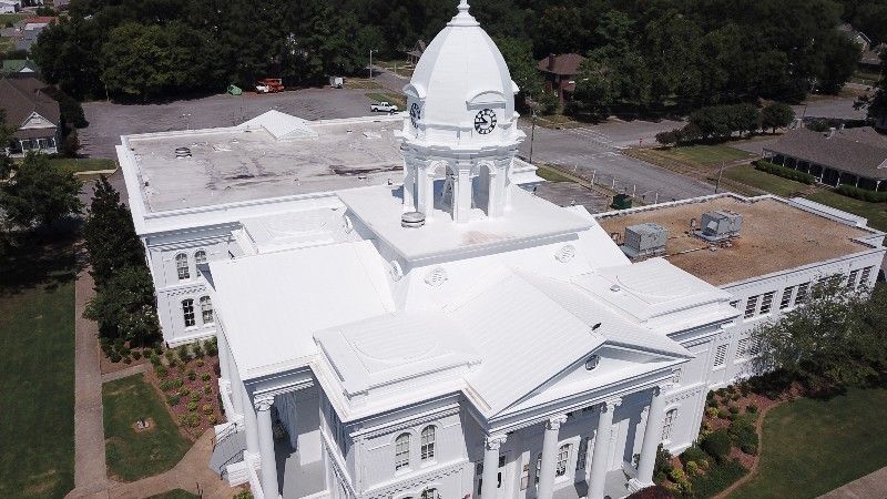 An aerial view of a large white building with a dome on top.