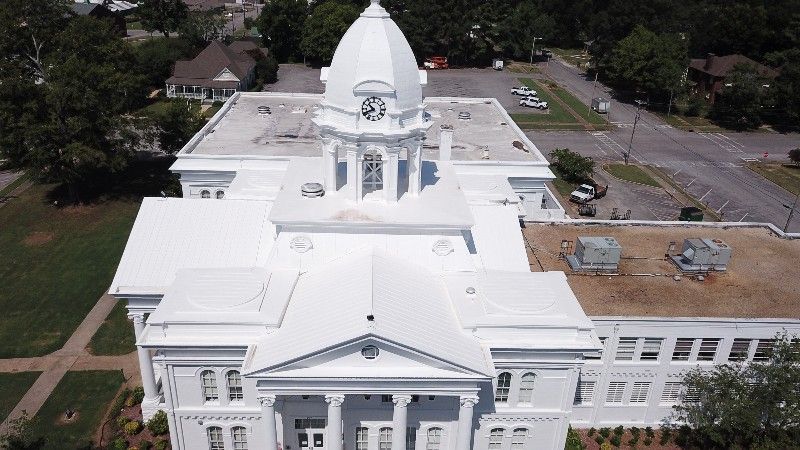 An aerial view of a large white building with a dome on top
