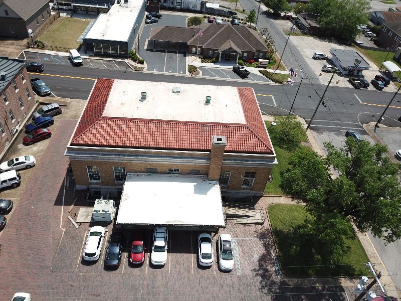 An aerial view of a building with cars parked in front of it