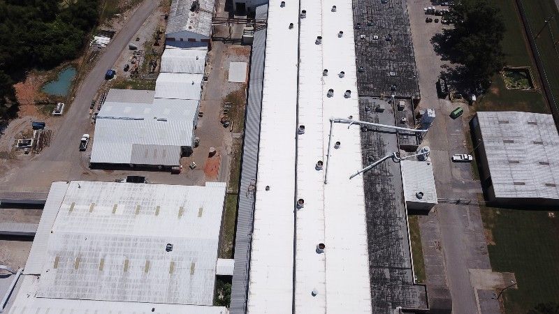 An aerial view of a factory with a white roof.