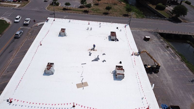 An aerial view of a large building with a white roof.
