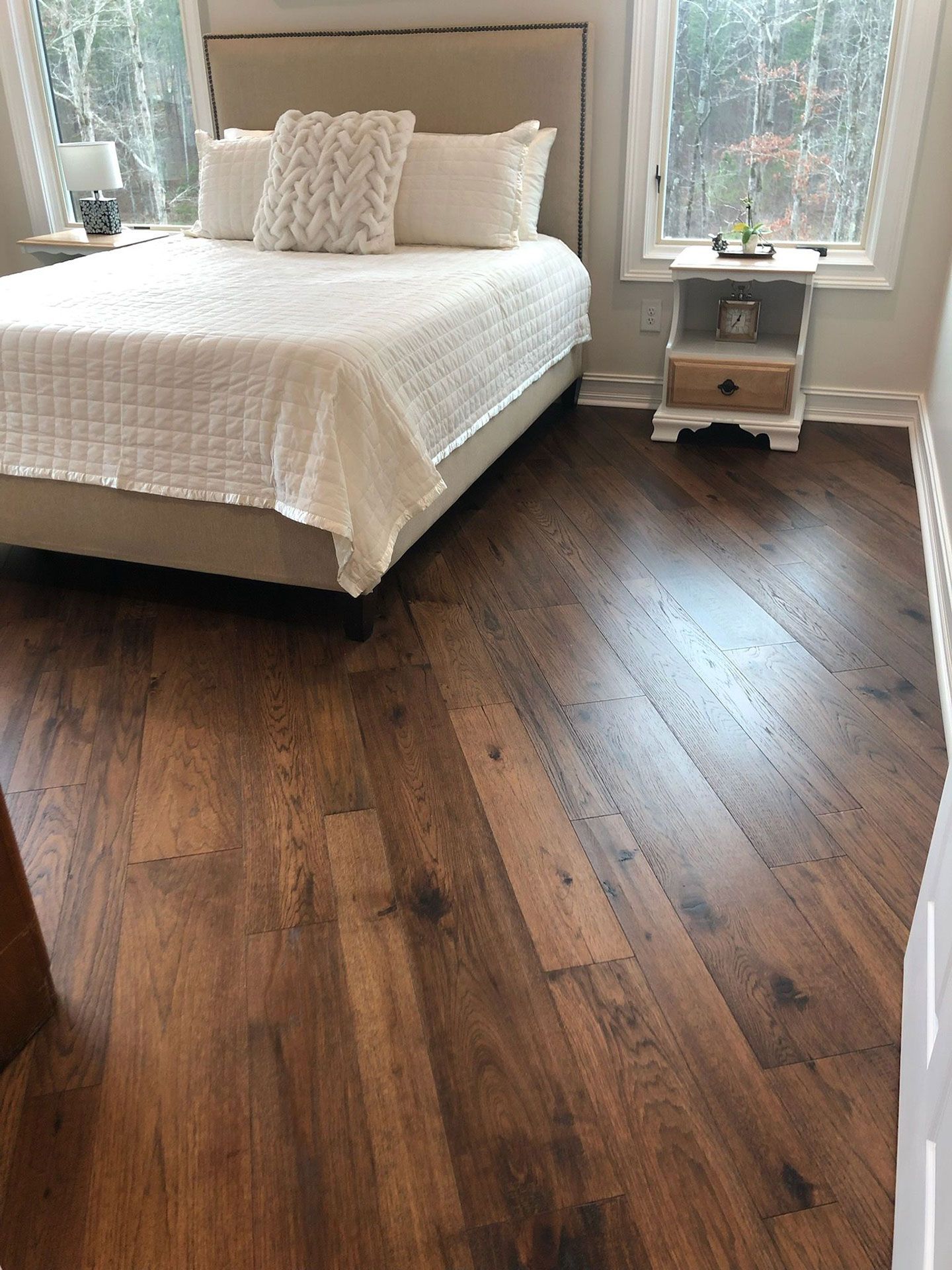 a bedroom with hardwood floors and a bed