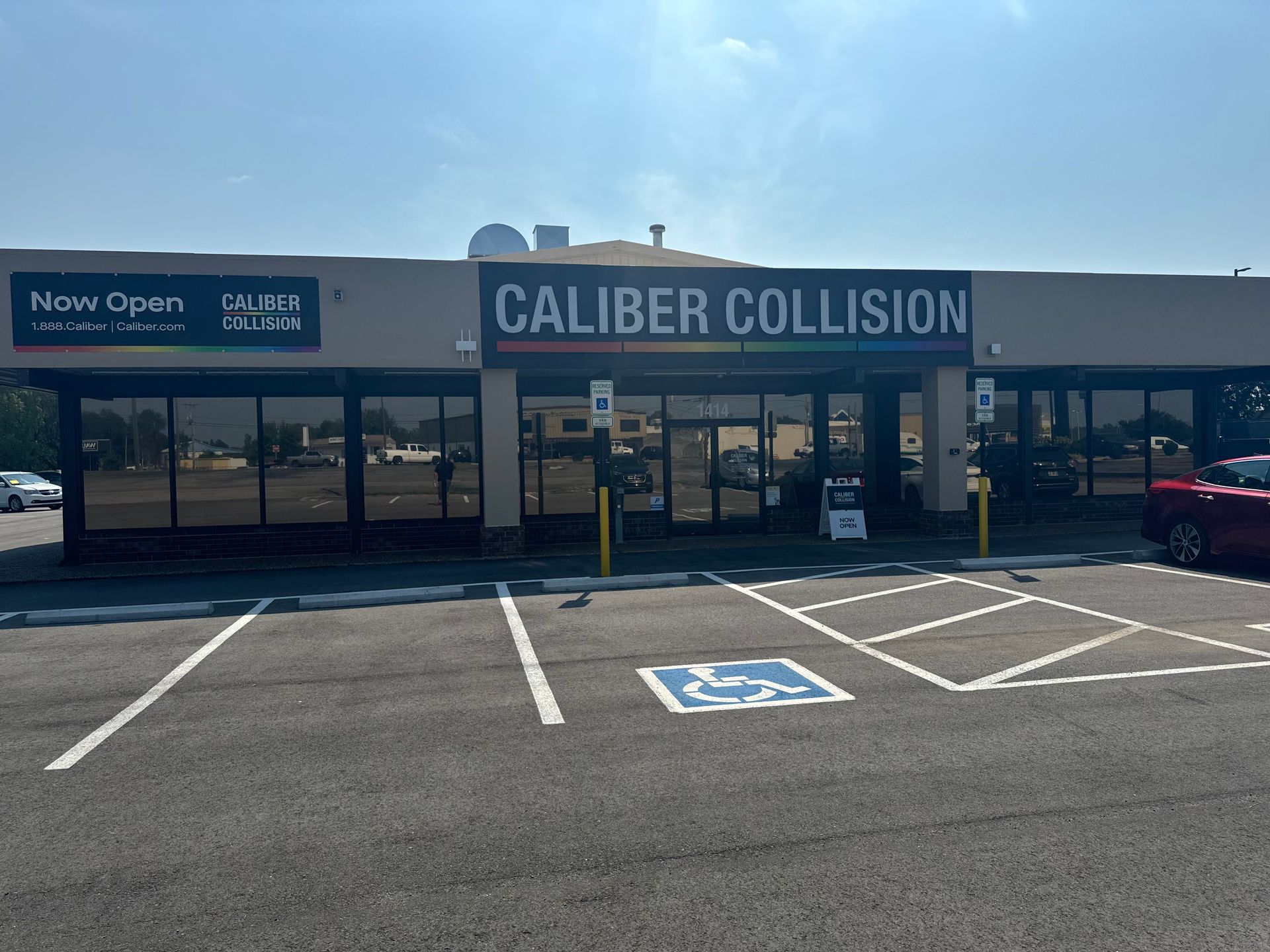 A car is parked in front of a caliber collision building.