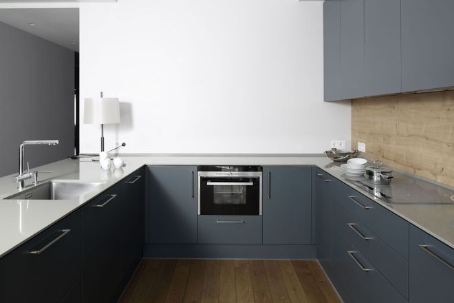 Modern U-shaped kitchen with dark cabinets, stainless appliances, and a gray countertop
