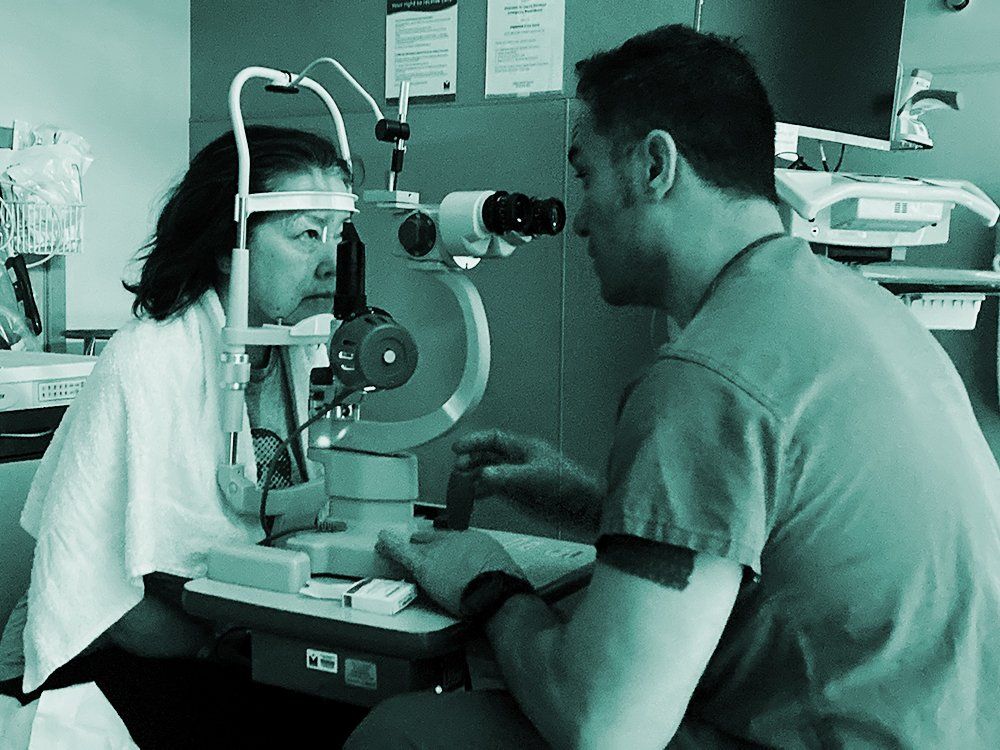 Optometrist testing a patient’s vision with an eye exam machine in a clinic