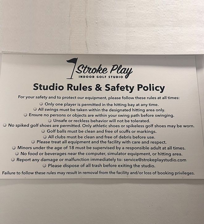 Studio Rules & Safety Policy sign on a wall above shelves, black text on white paper
