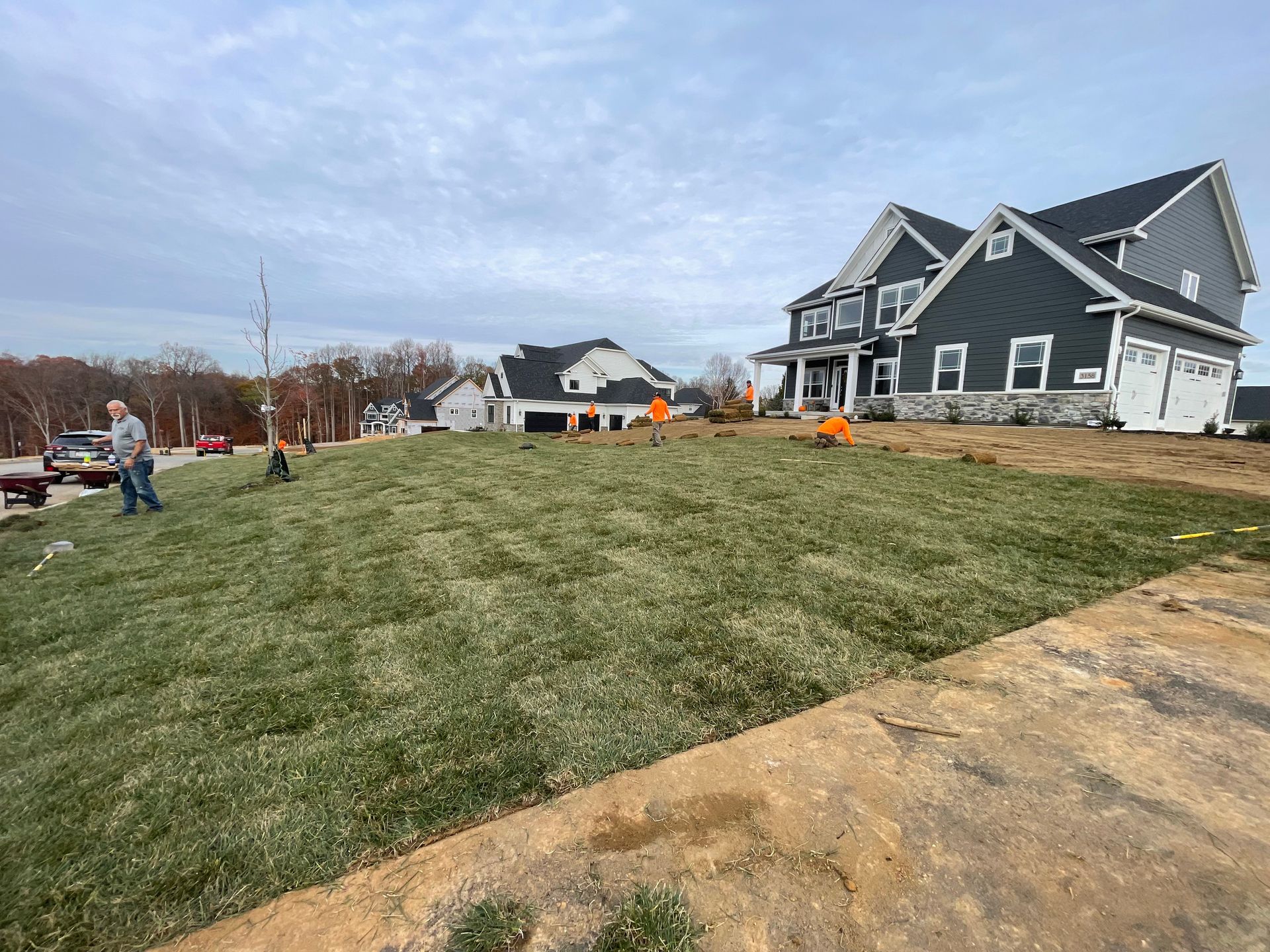Large new construction house with fresh sod being put down, instant grass