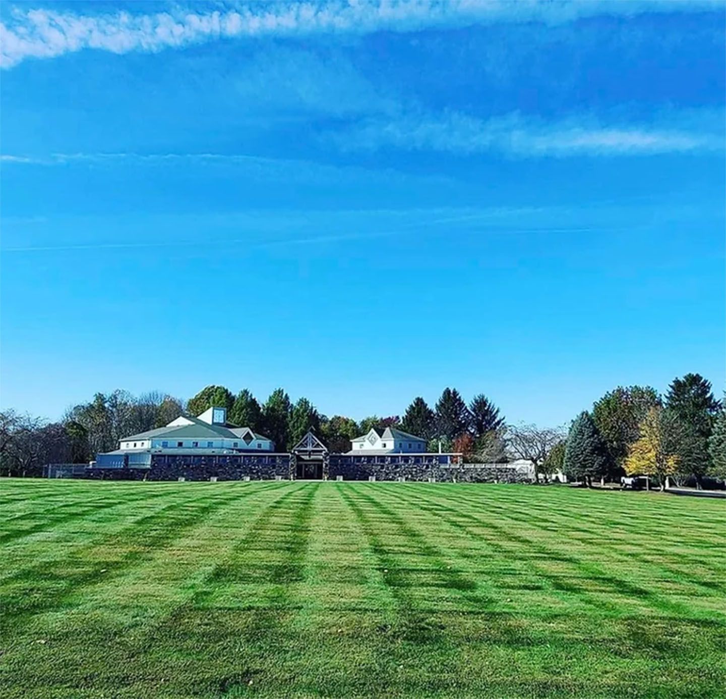 A large grassy field with a house in the background