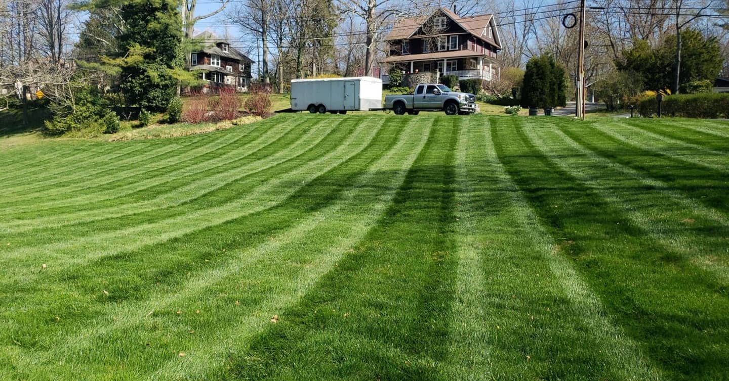 A truck is parked in the middle of a lush green lawn