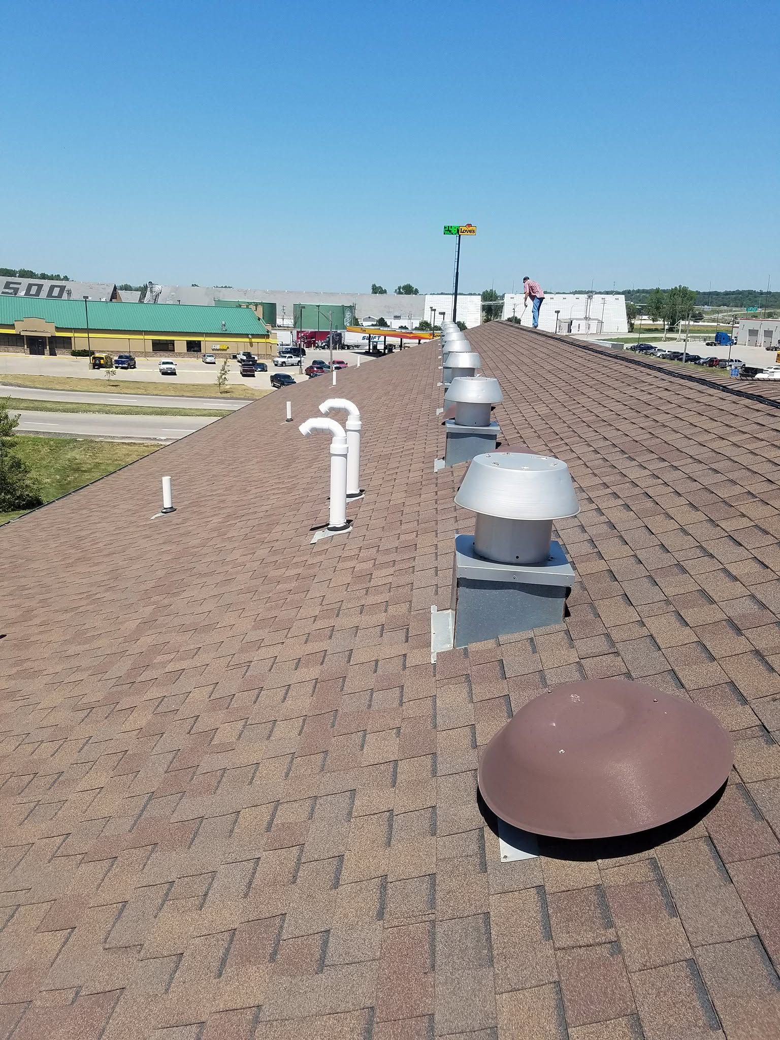 Rooftop with ventilation vents and a small flag under a clear blue sky.