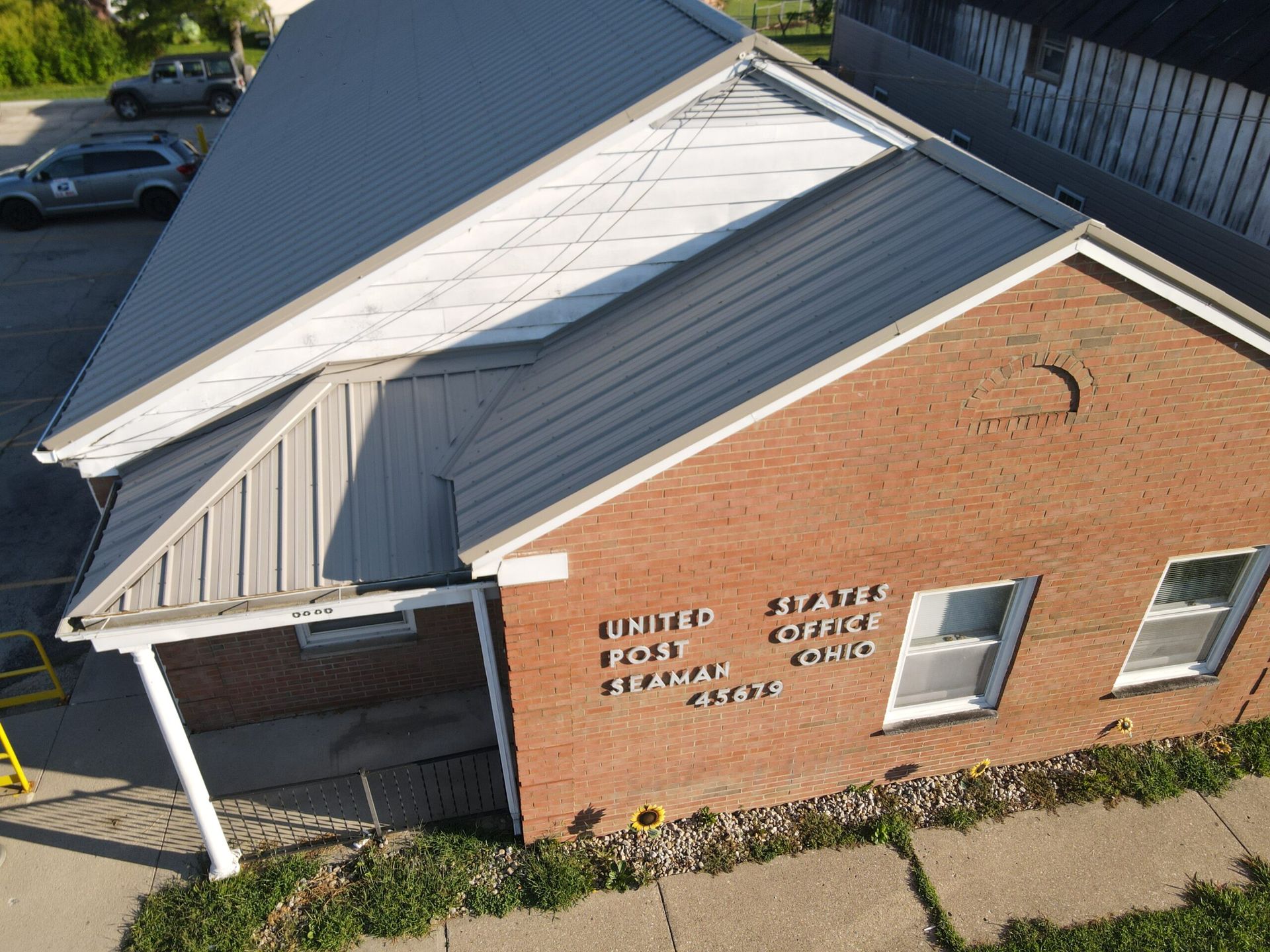 An aerial view of a brick building with a metal roof