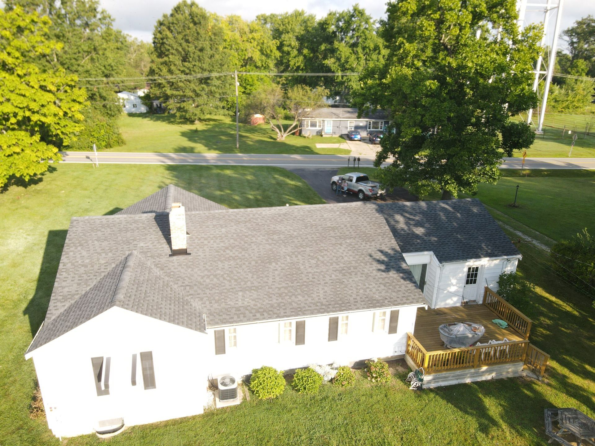 An aerial view of a white house with a black roof