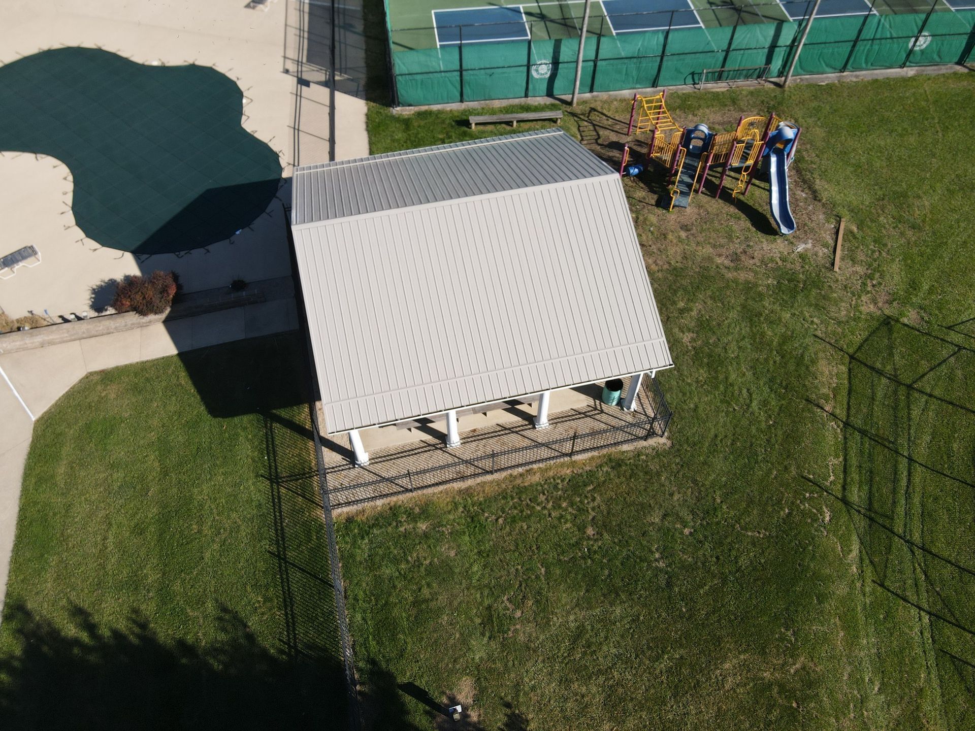 An aerial view of a playground and a tennis court
