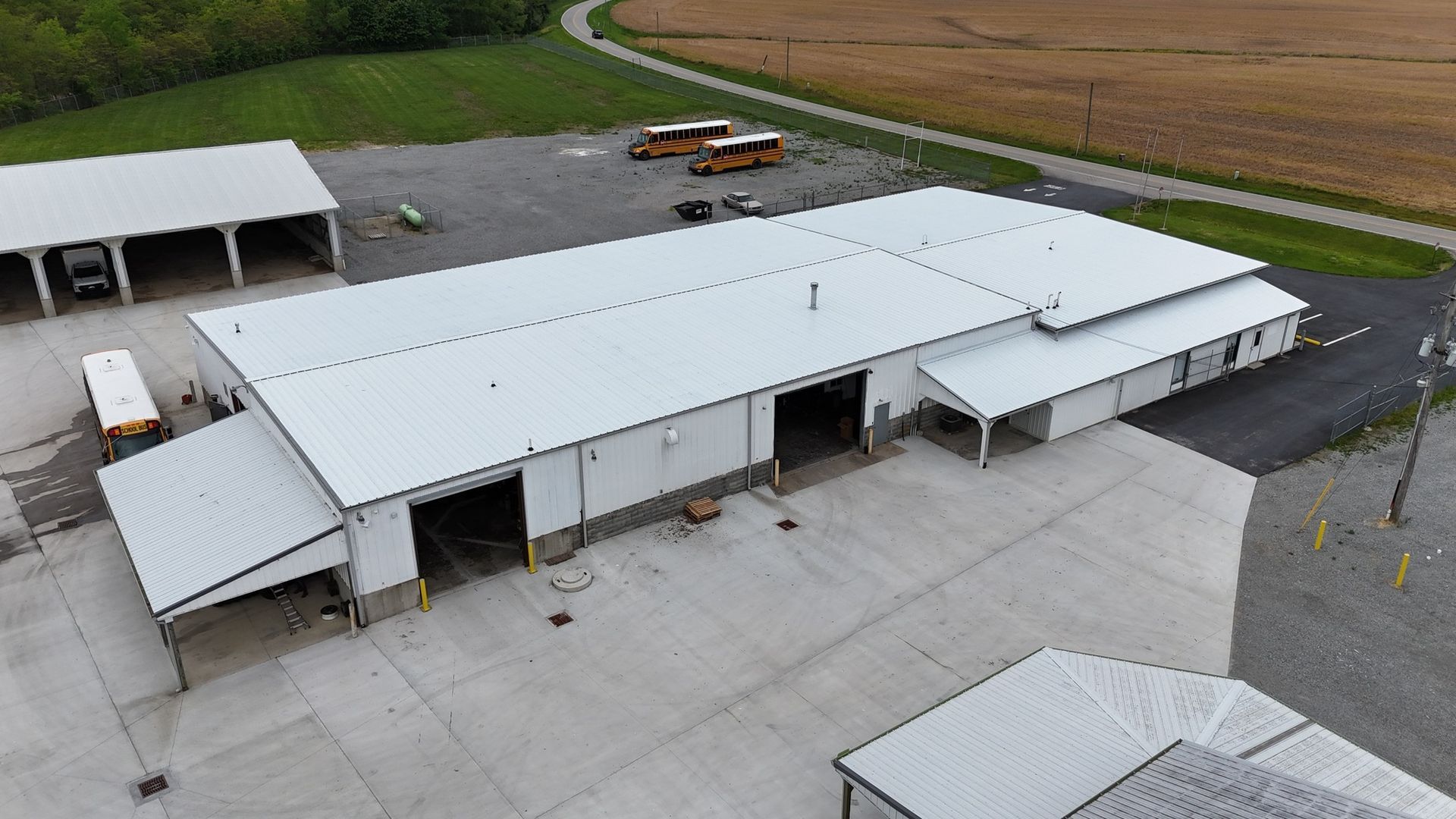 An aerial view of a large white building with a lot of vehicles parked in front of it.