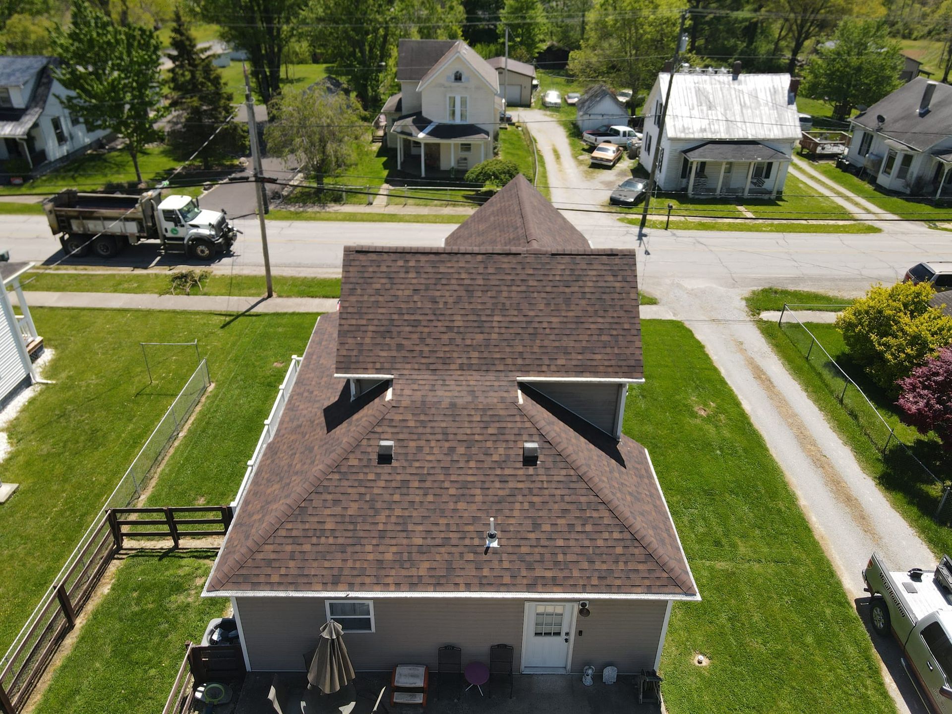 An aerial view of a house with a roof in a residential area.