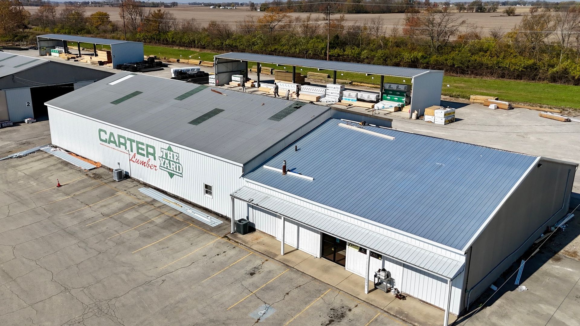 An aerial view of a large white building with a gray roof.