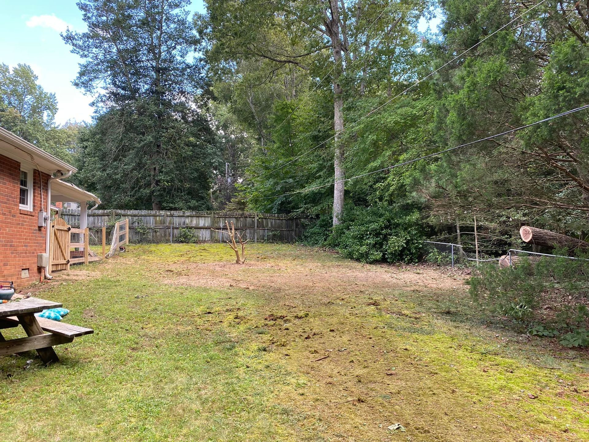 There is a picnic table in the backyard of a house.