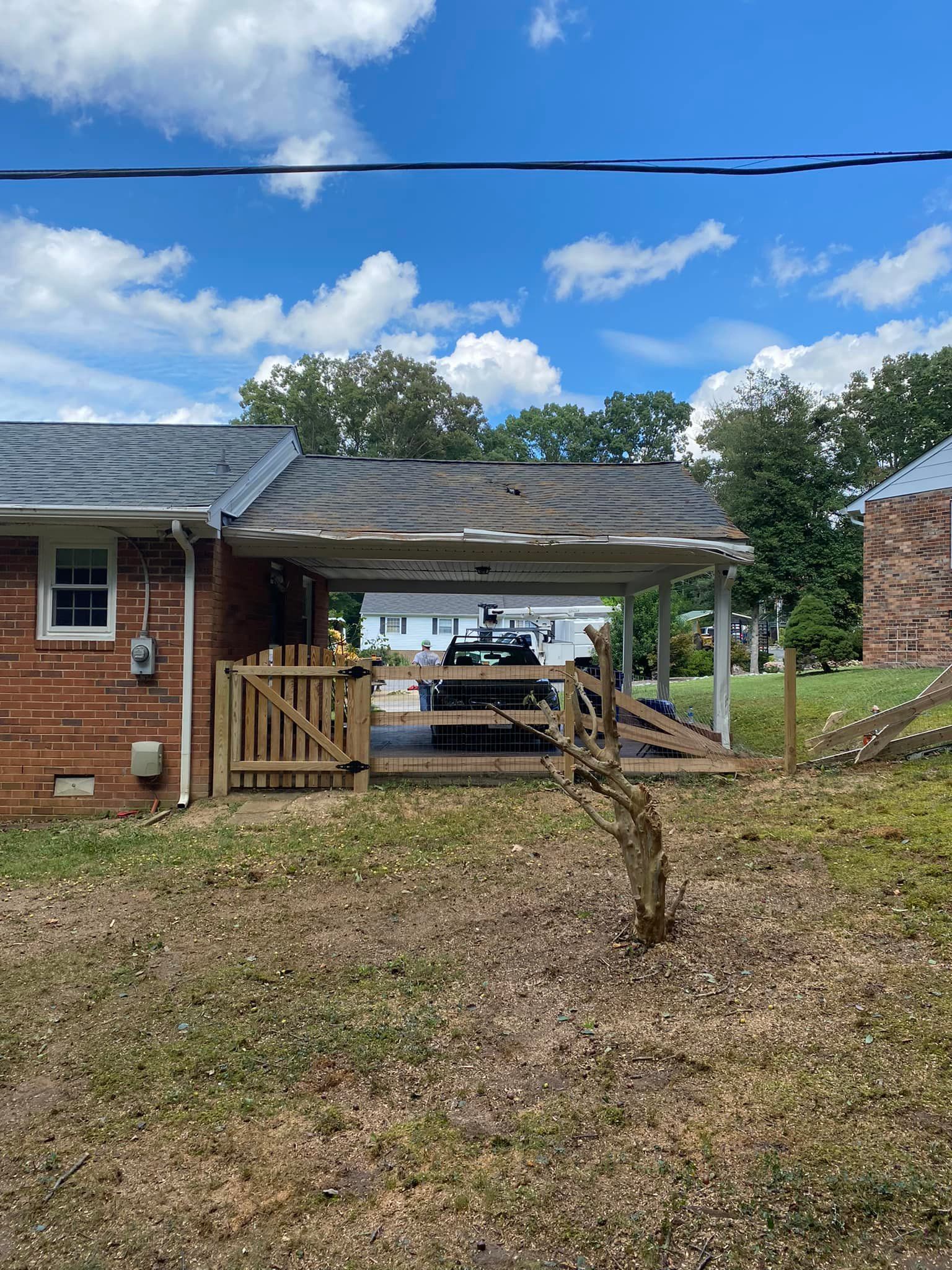 A brick house with a carport and a picnic table in front of it.