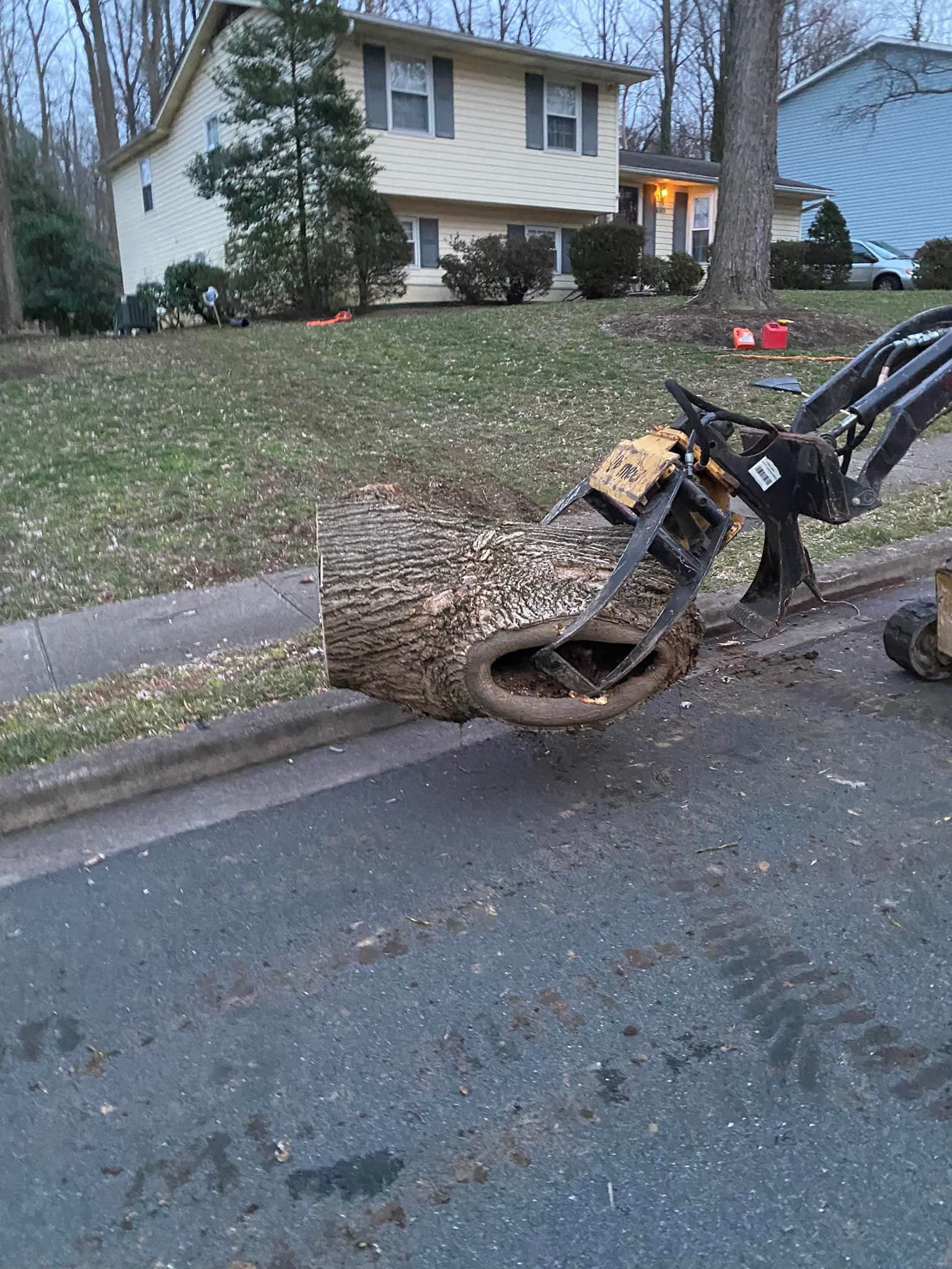 A large piece of wood is sitting on the side of the road next to a house.