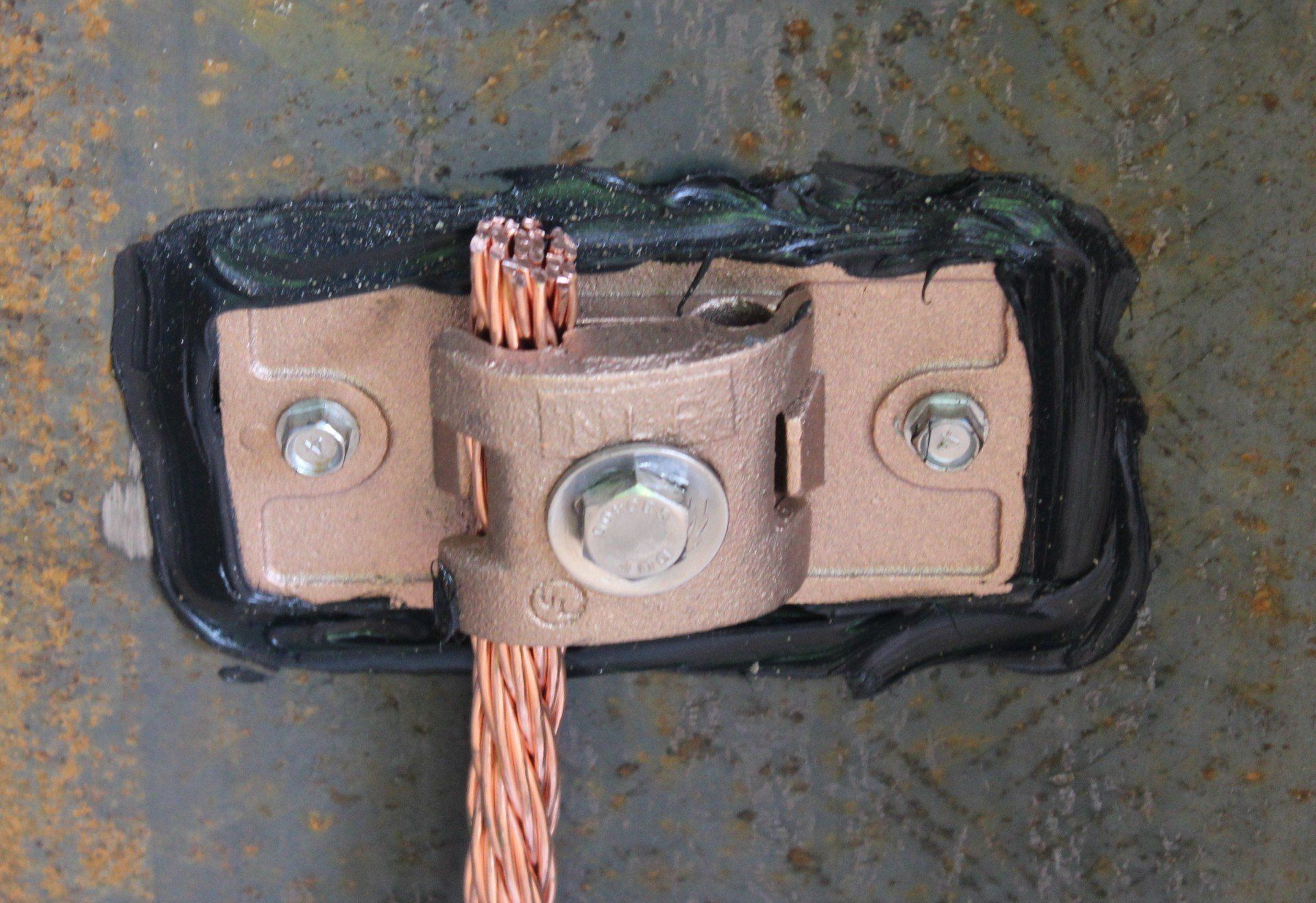 A close up of a copper wire attached to a metal surface.