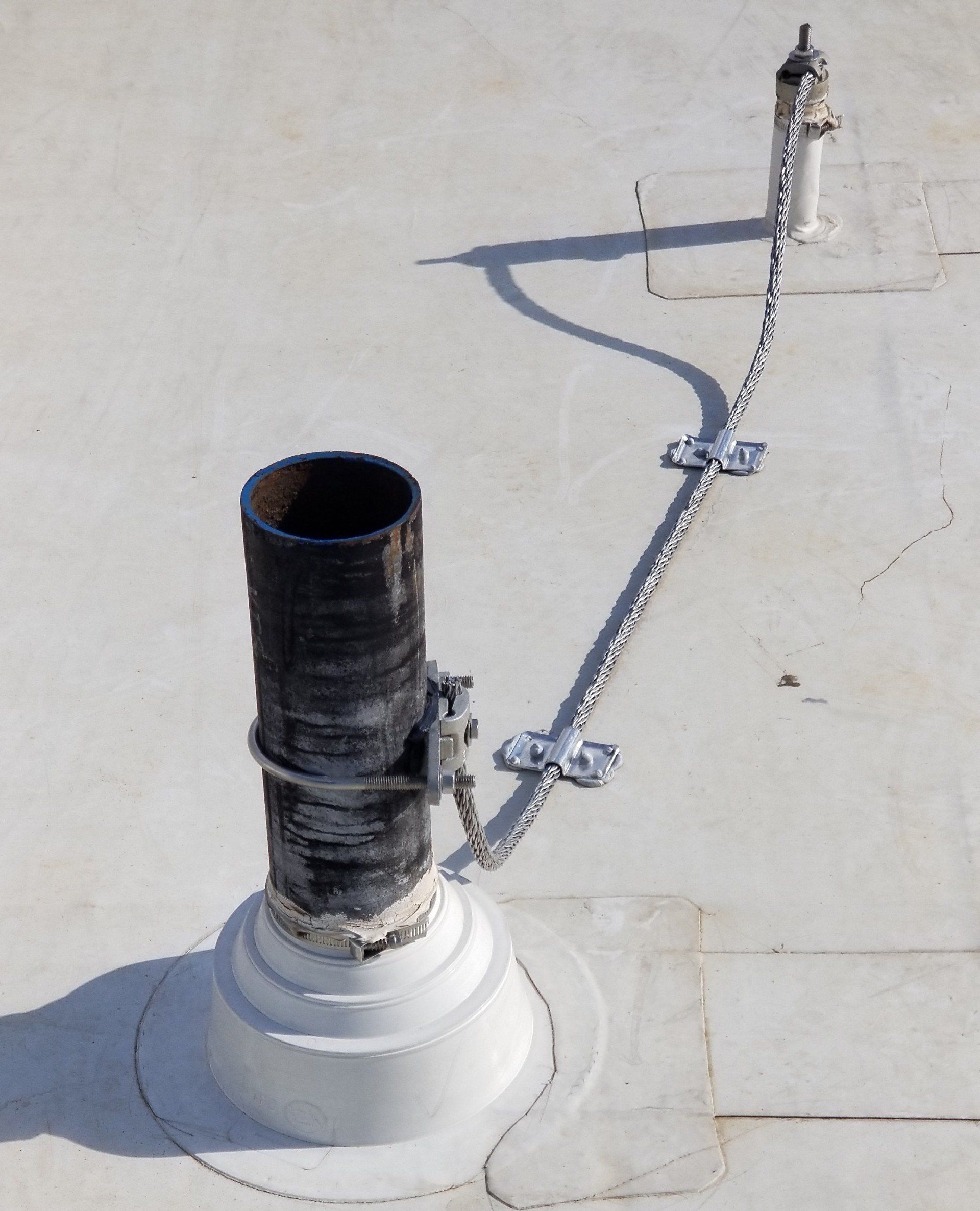 A pipe on a roof with a chain attached to it