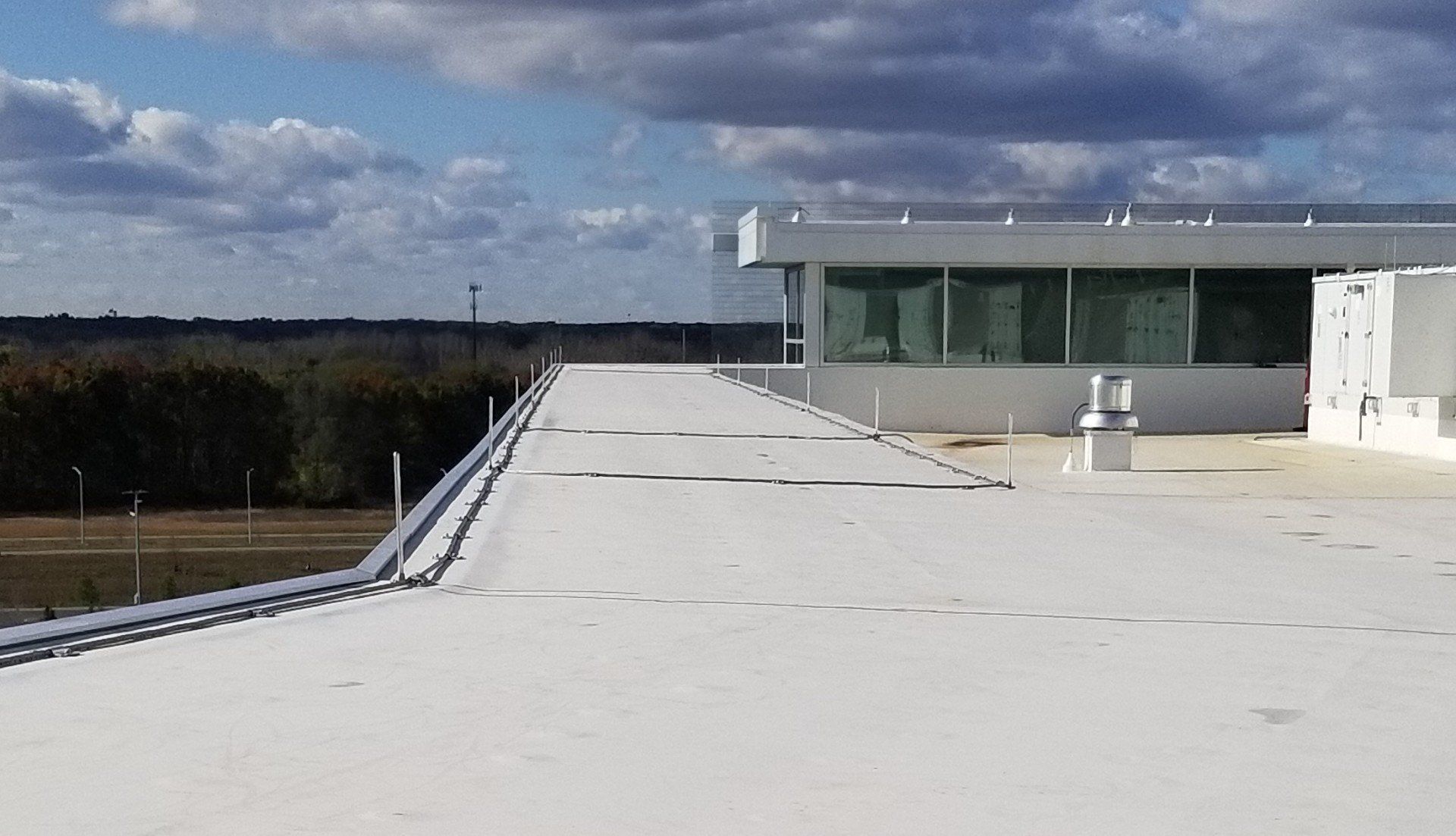 The roof of a building with a white roof and a blue sky in the background.