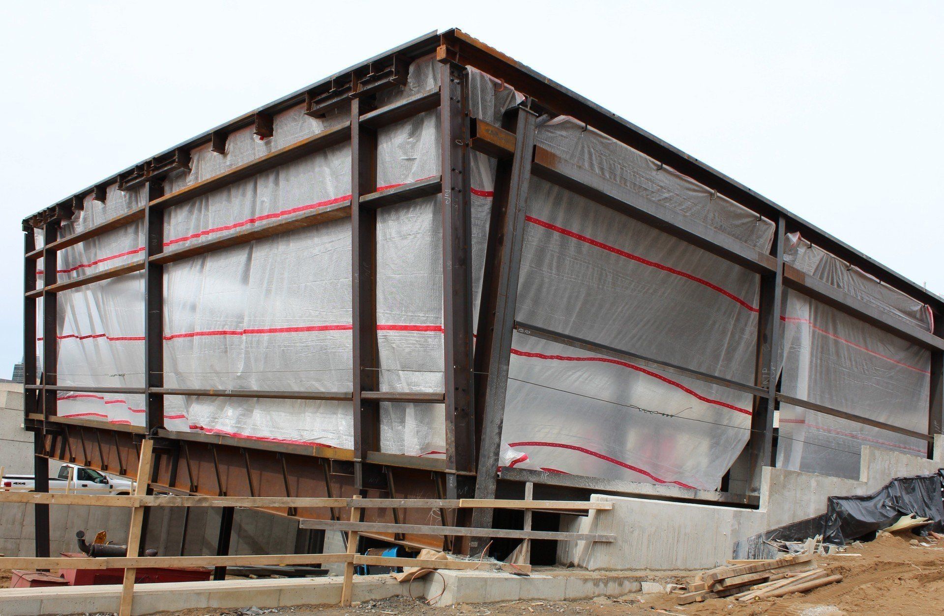 A large building is being built and is covered in plastic.