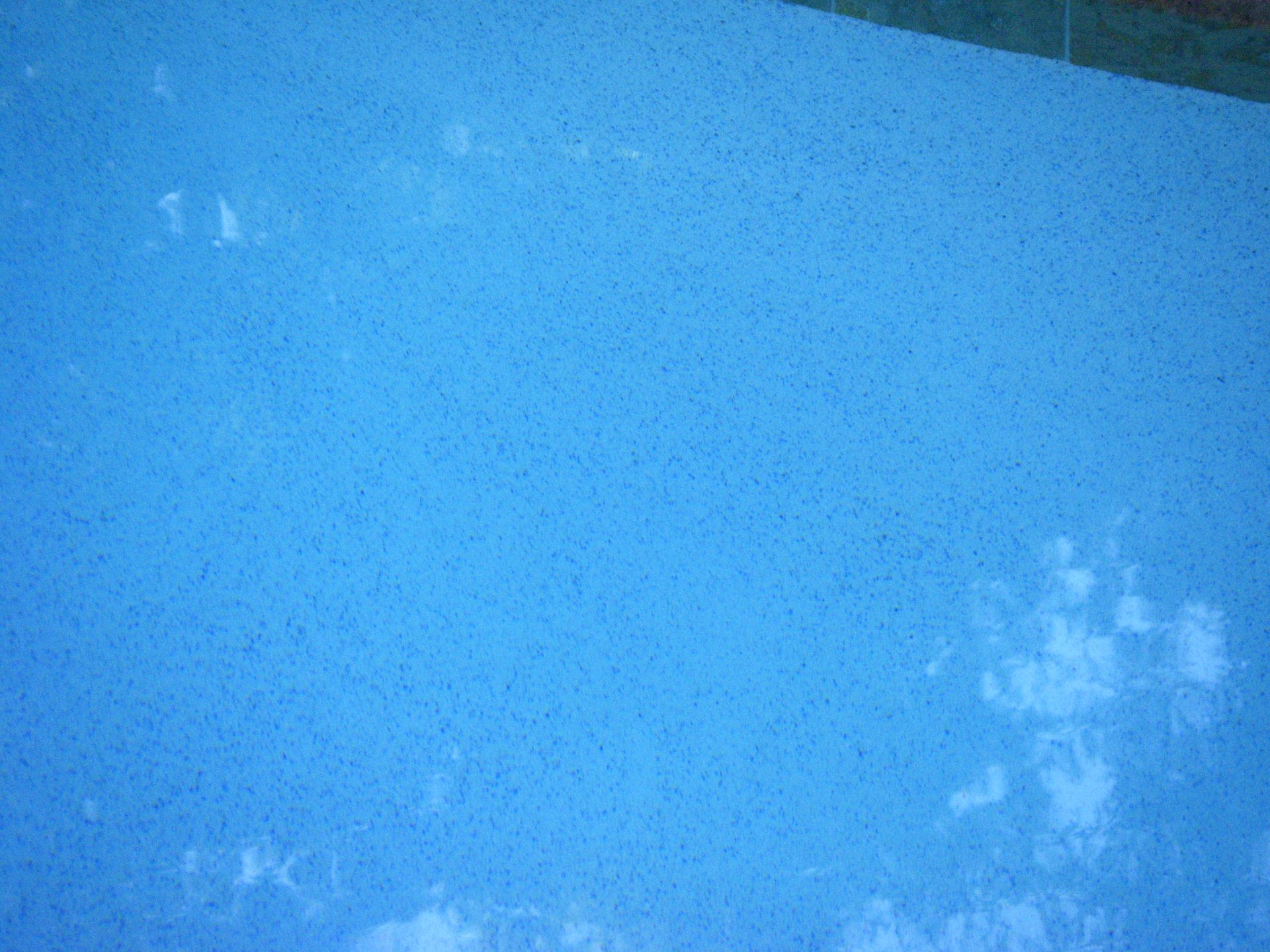 Blue sky with faint clouds and a bright cross-shaped reflection near the lower right.