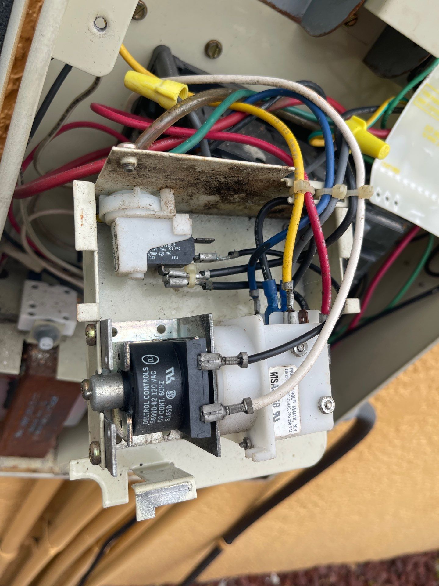 Close-up of exposed electrical switch wiring and metal components inside a device.