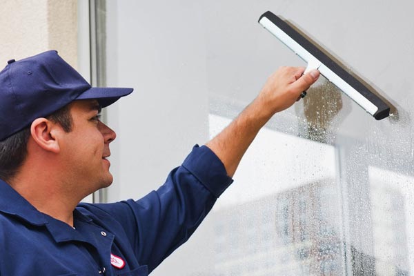 Man cleaning window with squeegee