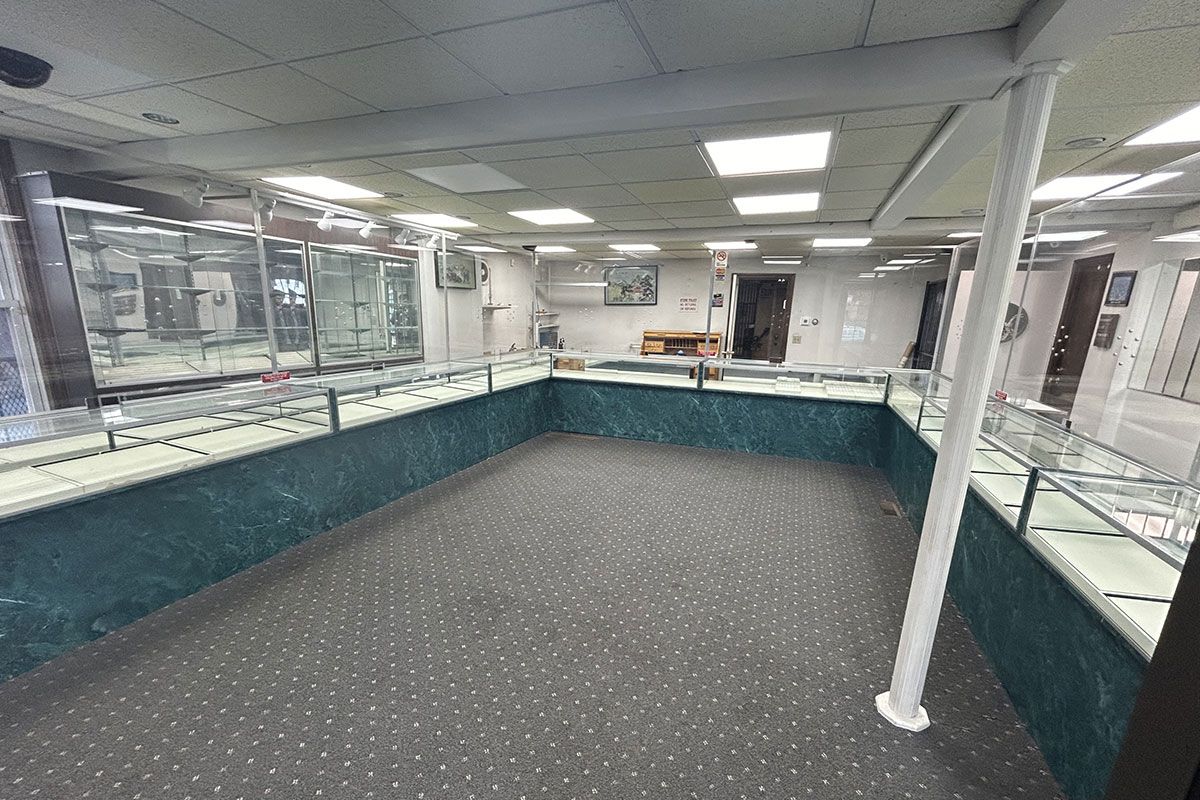 A large empty room with a lot of display cases in a jewelry store.