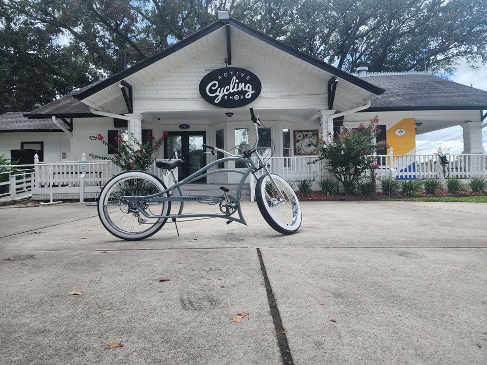 A bicycle is parked in front of a building that says cycling.