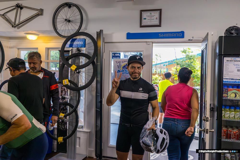 A man is holding a helmet in a bicycle shop.