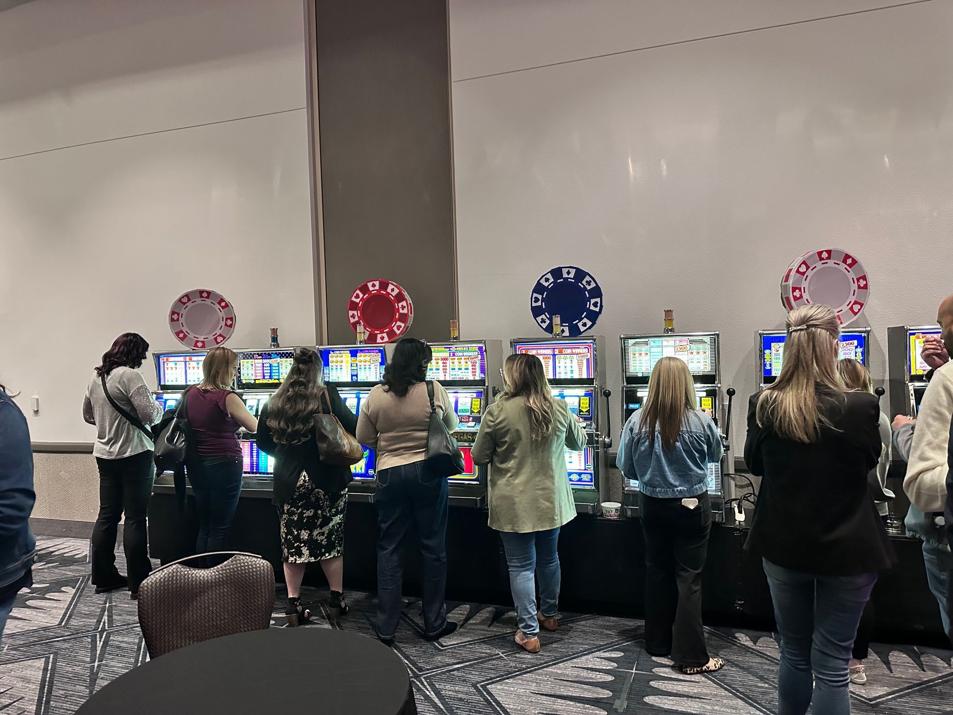 A group of people are playing slot machines in a casino.