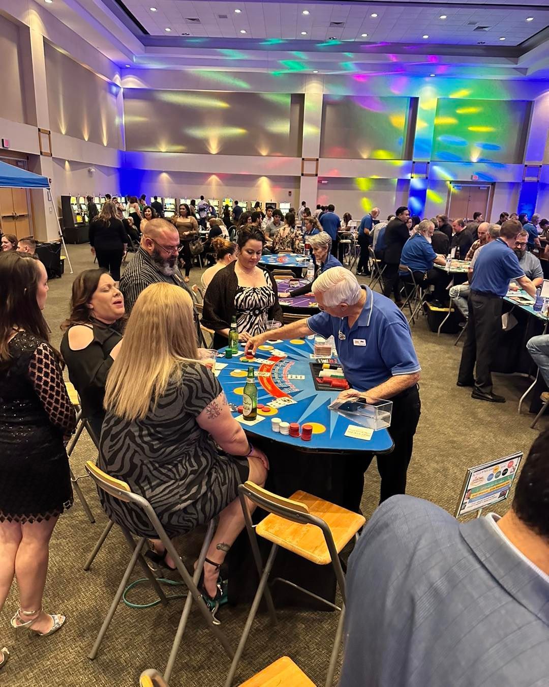 A group of people are sitting at tables in a large room.