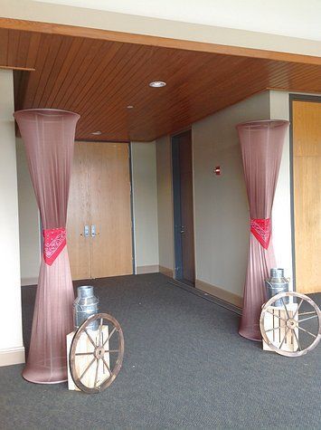 A hallway with columns and wagon wheels decorated for a western theme.