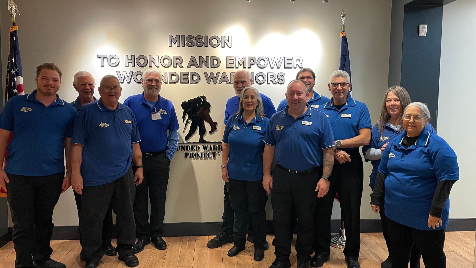 A group of people in blue shirts are posing for a picture.