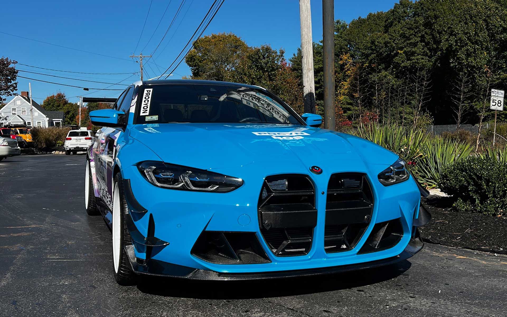 A blue bmw m4 is parked in a parking lot.