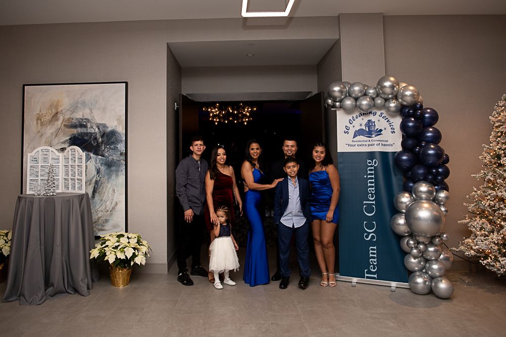 Family posing in front of a banner for