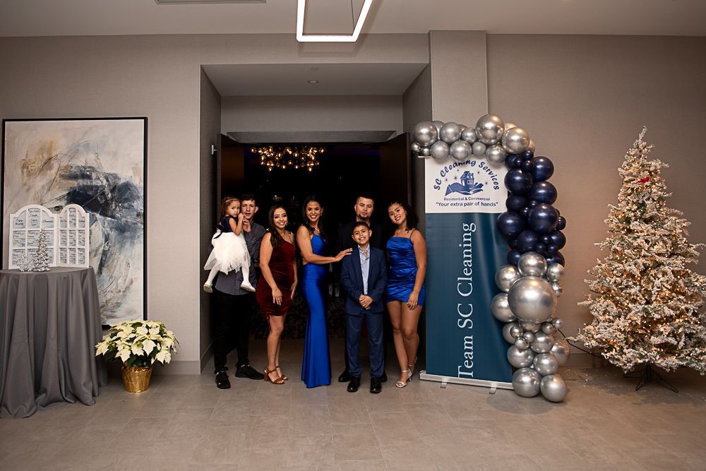 Group of people at event, posing near banner for