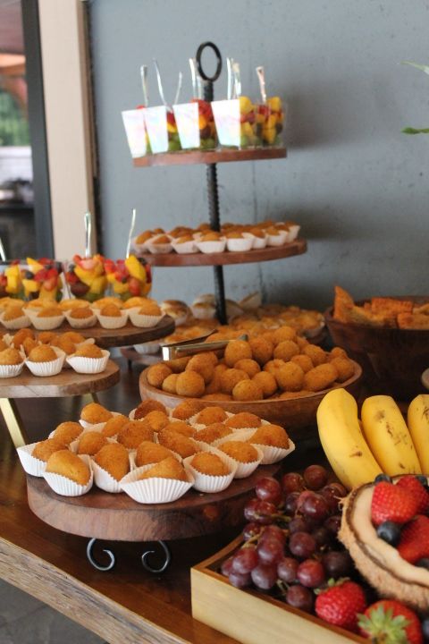 Buffet table with fruit, pastries, and appetizers on wooden platters.