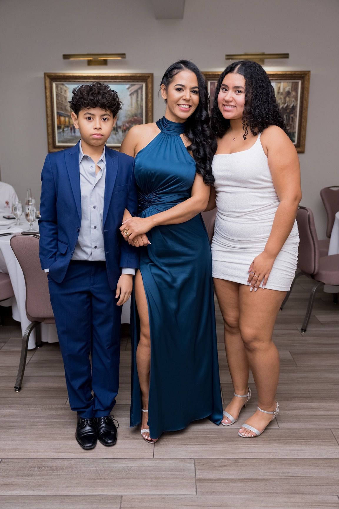 Woman in blue dress with son and daughter at event. Formal wear.