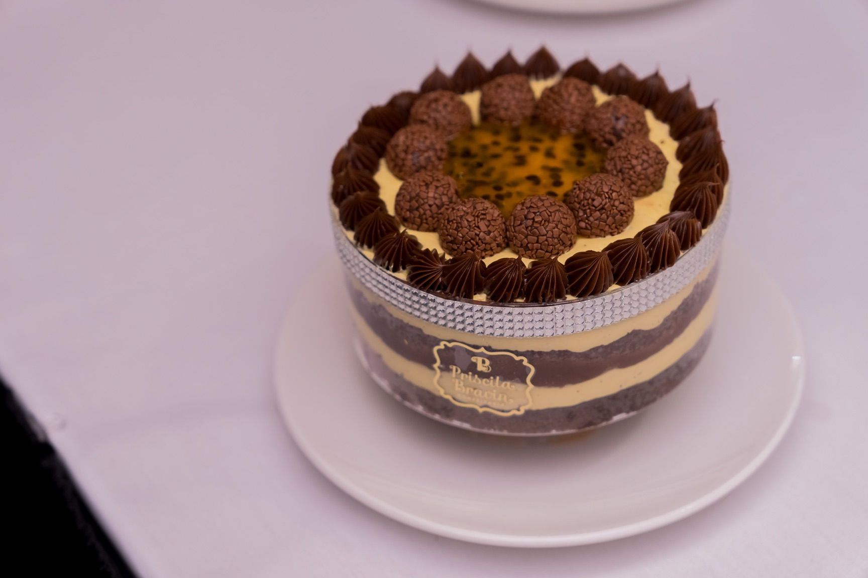 Cake with chocolate and passion fruit, decorated on a white plate.