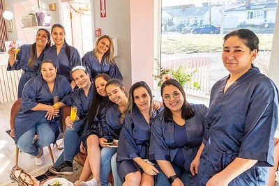 Group of women in blue robes and jeans, celebrating indoors.